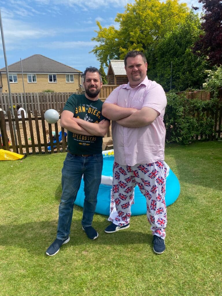 Two men posing confidently in a garden