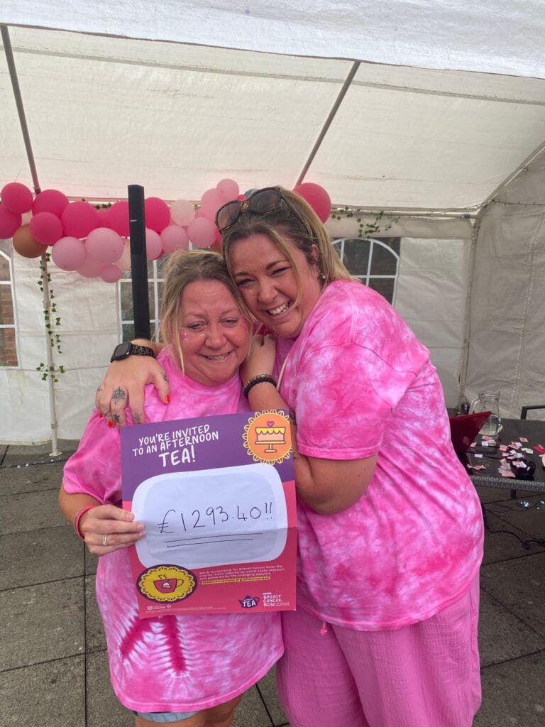 Two women celebrating charity fundraiser in pink clothes