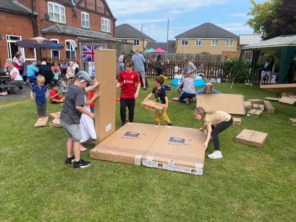 Children building with cardboard boxes outdoors