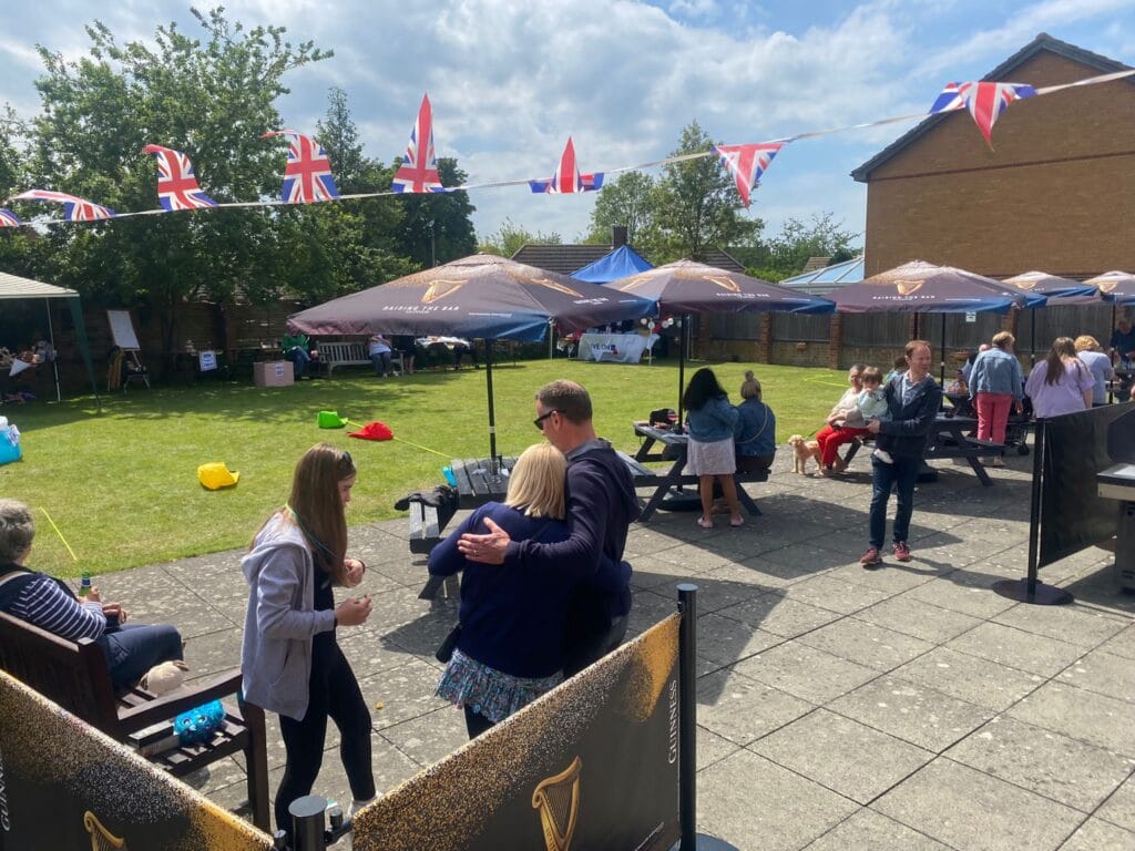 People enjoying outdoor summer party with British flags.