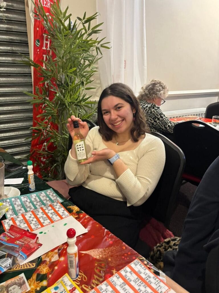 Woman smiling and holding a bottle at bingo event