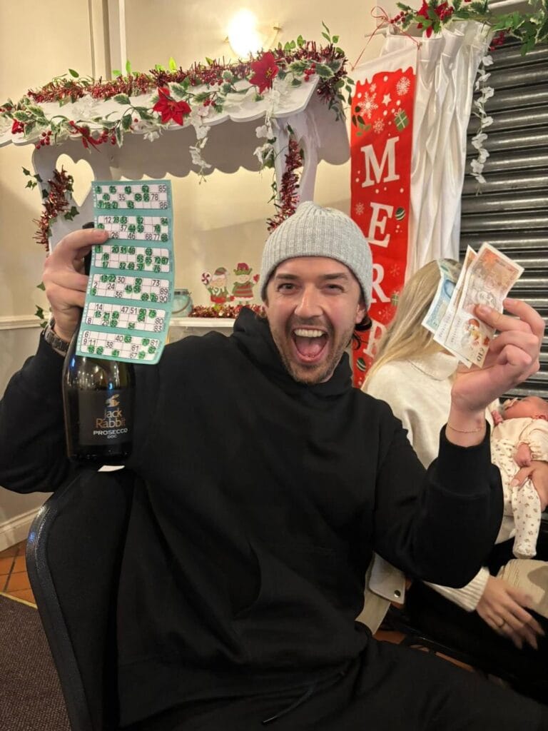 Man celebrating bingo win with cash and prosecco