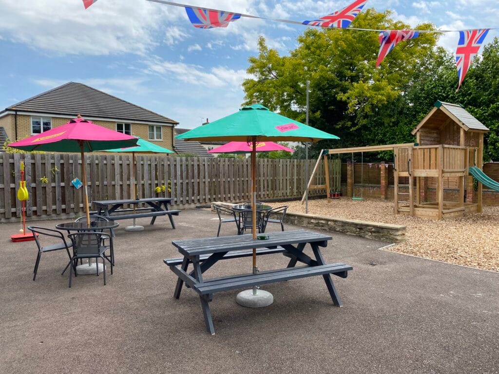 Outdoor seating area with playground and colourful parasols