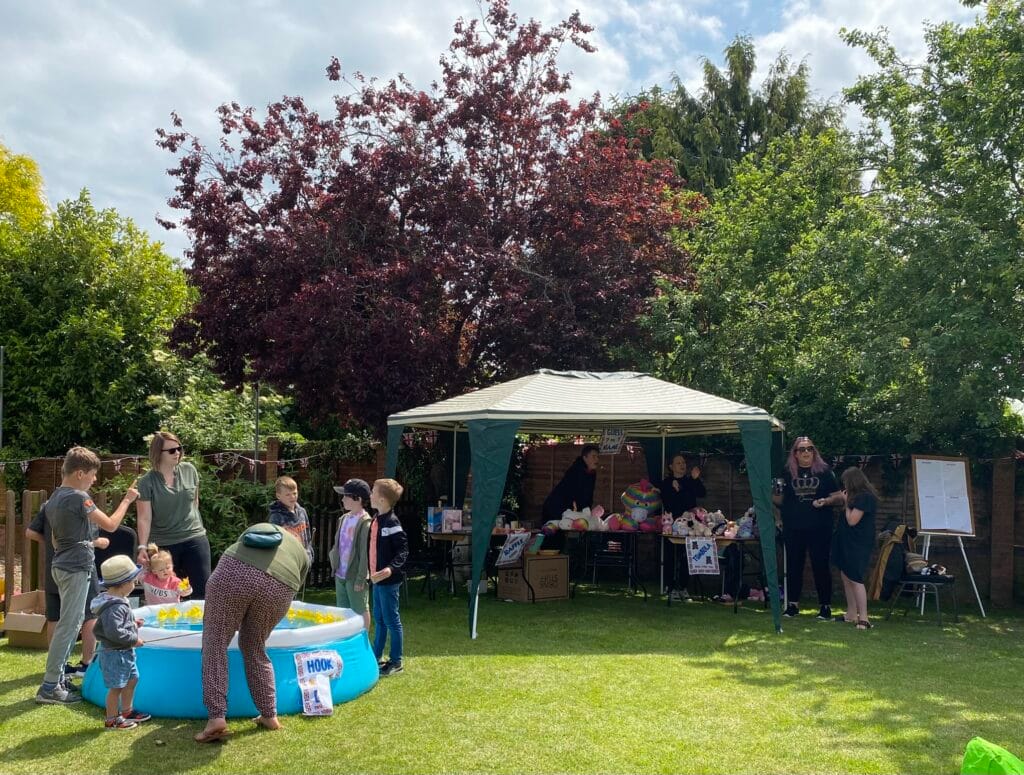 Families enjoying outdoor fair games and stalls
