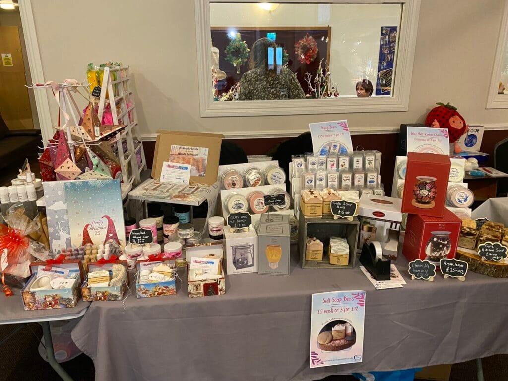 Market stall displaying handmade soaps and bath products.