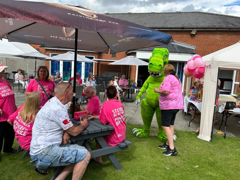 Community cancer fundraiser with people and dinosaur mascot