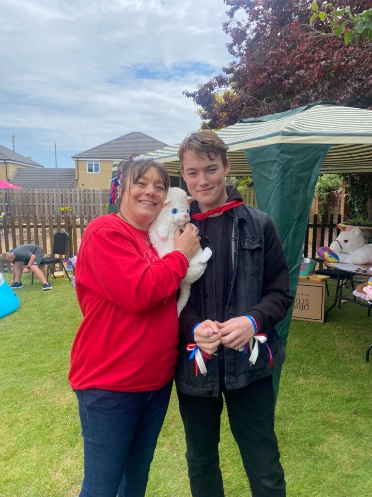 Two people smiling at outdoor fair holding a toy