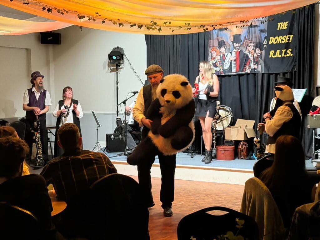 Live band performance with panda costume on stage